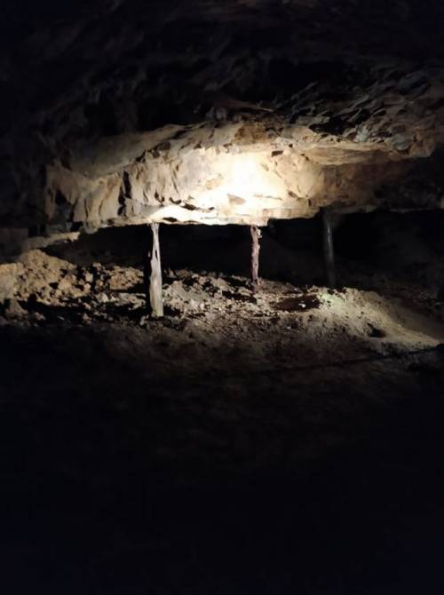 Wnętrze korytarza w kopalni z podkładami podpierającymi sufit