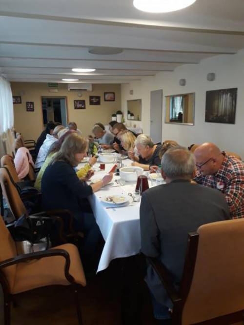 Grupa kobiet i mężczyzn w trakcie obiadu