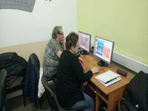 Dwie kobiety siedzą przy stanowiskach komputerowych