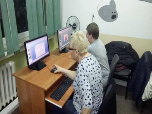 Dwie kobiety siedzą przy stanowiskach komputerowych